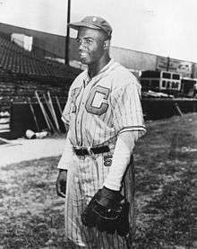 An African American man wearing a pinstriped baseball uniform, hat 